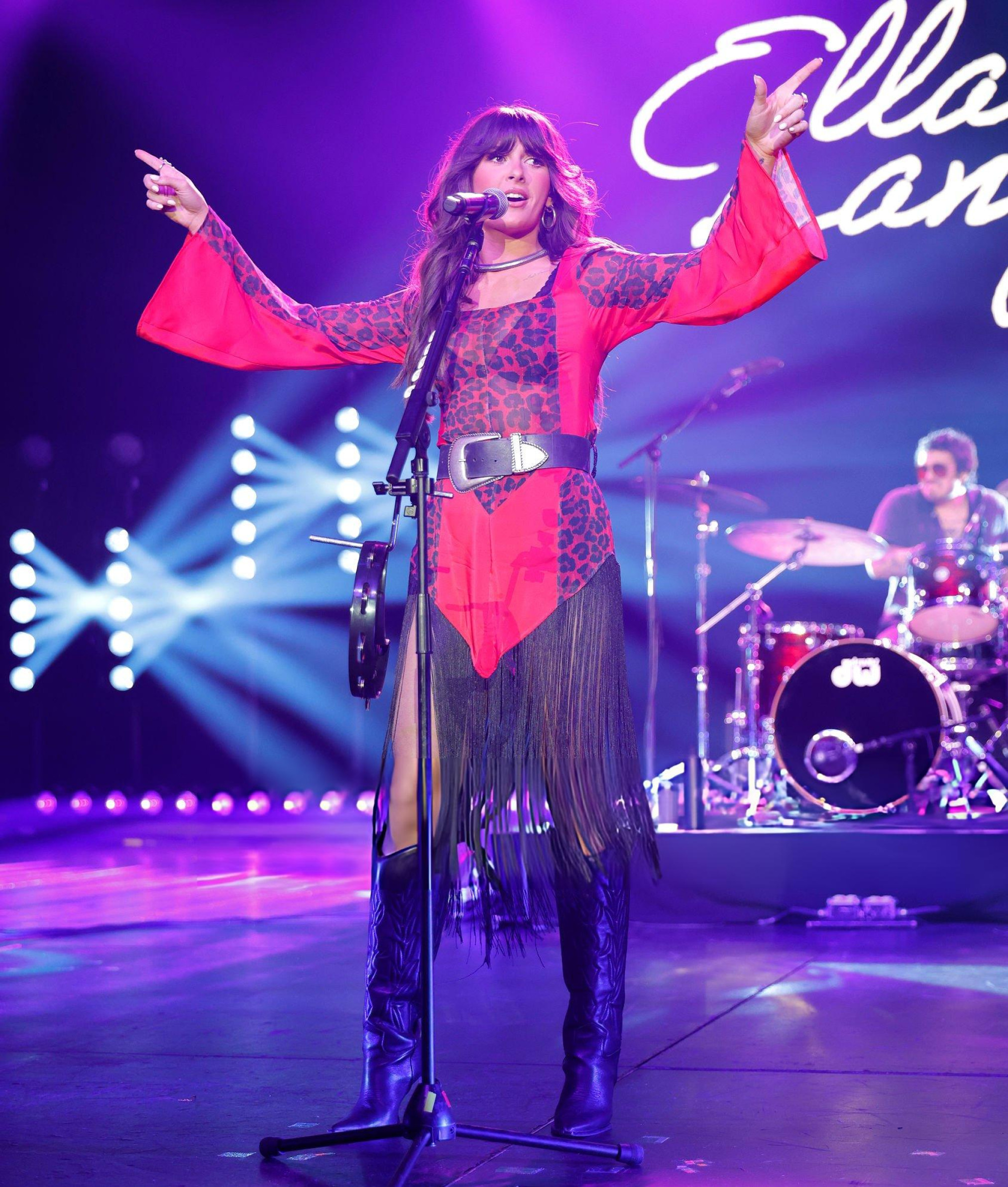 Ella Langley performing in a red and black leopard stage look with long fringe
